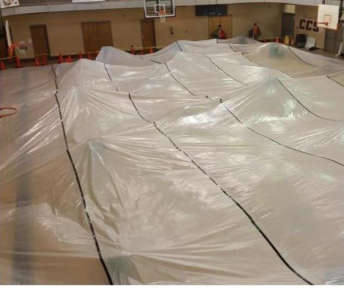 Plastic tent covering gymnasium floor.