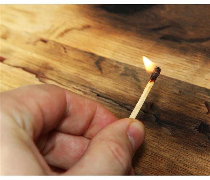 Hand holding a lighted match