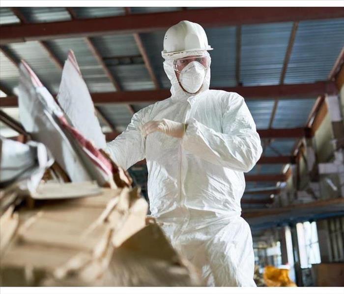 Man wearing protective gear while sorting cardboards